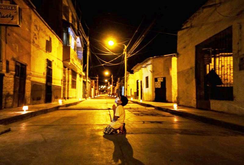 De joelhos e no meio da rua menino pede a Deus pelo fim do coronavírus