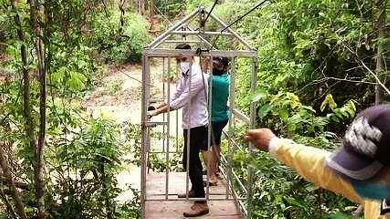 Sem ponte, moradores improvisam gaiola e se arriscam para atravessar córrego