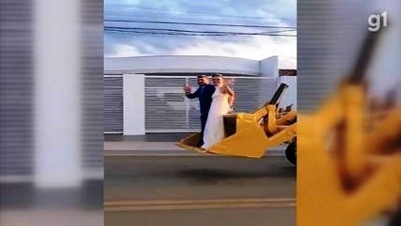Recém-casados desfilam em retroescavadeira após cerimônia e viraliza