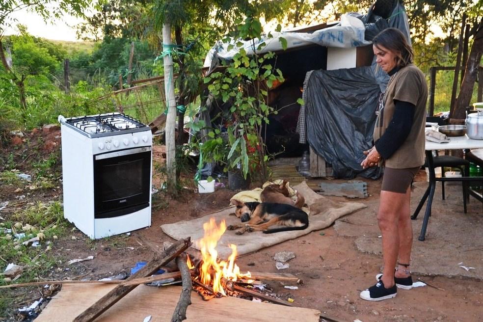 Mulher vive há quase dois anos em barraco de lona e improvisa fogueira para escapar do frio