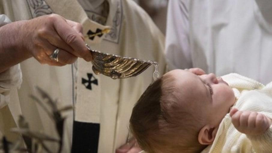 Padre batiza bebê com mistura de água benta e ácido