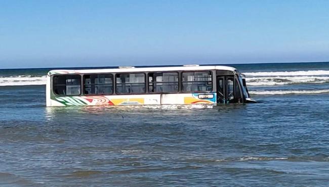Ônibus fica atolado em praia durante ressaca e chega a ficar 80% coberto pela água